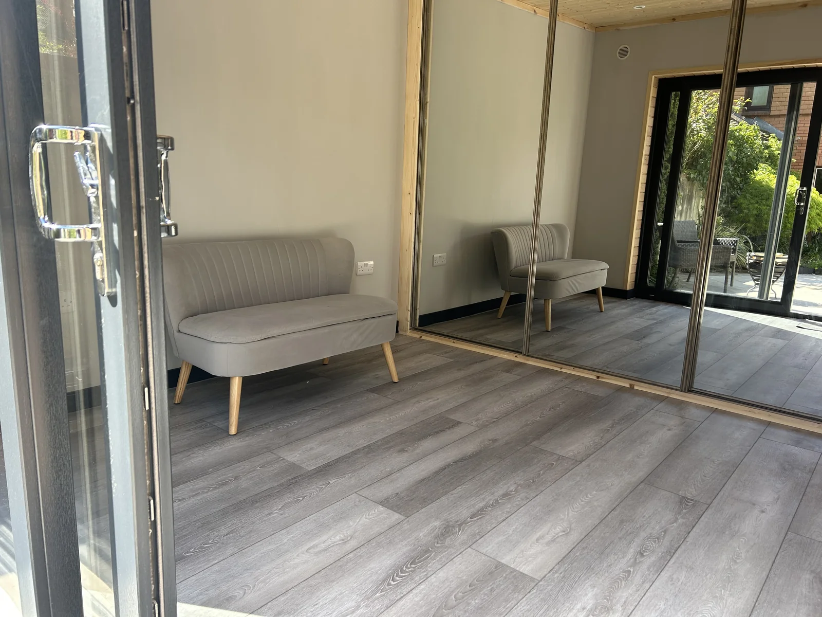Built-in wardrobe with mirrored sliding doors in garden room